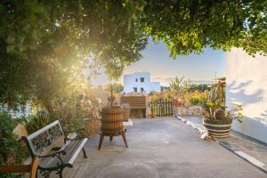 a patio with a bench and some plants and a building at Matina's Family in Mikri Vigla
