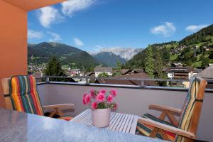 a table and chairs on a balcony with a view of mountains at Tonis Appartement in Schruns