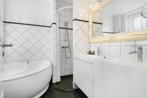 ein weißes Badezimmer mit Badewanne und Waschbecken in der Unterkunft Hotel Tiffany in Kopenhagen + 50 Fotos