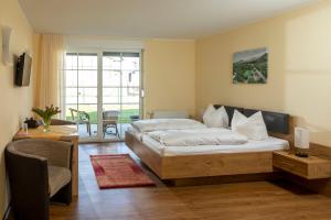 a bedroom with a bed and a living room at Parkpension Spreewald in Burg