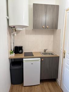 a small kitchen with a sink and a counter at Super appartement in Malesherbes +10 photos