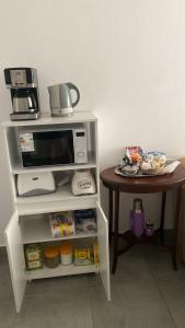a microwave on a shelf next to a table at El Remanso de Paracao in Paraná +6 photos