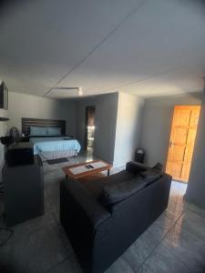a living room with a couch and a bed at Exodus Guesthouse Mahlakwena Stee'lpoort in Steelpoort