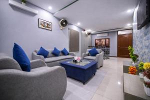 a living room with couches and blue pillows at Private 2BD Apartment Opposite Dha Phase 8 in Lahore