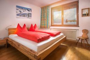 a bedroom with a bed with red pillows and a window at Tonis Appartement in Schruns
