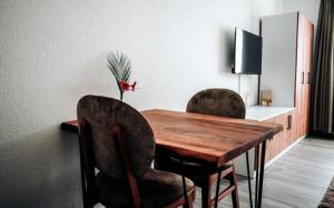 a dining room table with two chairs and a television at E&B Apartments Waiblingen bei Stuttgart in Waiblingen