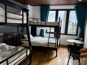 a room with three bunk beds and a table at Sapa Landscape Homestay in Sapa