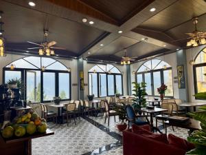 a restaurant with tables and chairs and windows at Sapa Landscape Homestay in Sapa