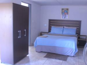 a bedroom with a large bed with a wooden headboard at Exodus Guesthouse Mahlakwena Stee'lpoort in Steelpoort