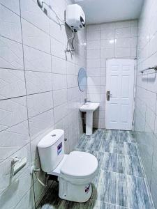 a white bathroom with a toilet and a sink at Premium Luxury Apartments in Abuja +7 photos