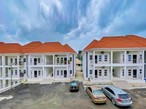 two buildings with cars parked in a parking lot at Premium Luxury Apartments in Abuja
