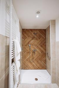a bathroom with a shower with a wooden wall at Hotel Kleiner Riesen in Koblenz