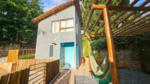 a small house with a blue door and a fence at Saíra Chalés in Lençóis