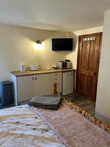 a room with a bed and a kitchen with a counter at Crowtrees Barns in Waterhouses