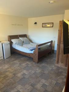 a bedroom with a bed and a small refrigerator at Crowtrees Barns in Waterhouses