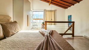 a bedroom with a bed and a large window at Saíra Chalés in Lençóis