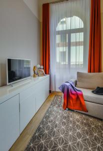 a living room with a couch and a television at Amalienhof Serviced Apartments in Weimar