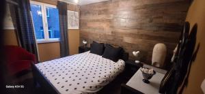 a bedroom with a bed and a wooden wall at Le Dépôt in Spa
