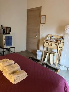 a room with a bed and a table with towels at Verso Est in Petralia Soprana
