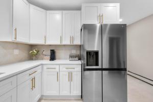 a kitchen with white cabinets and a stainless steel refrigerator at Blatchley Rooms by Yale in New Haven