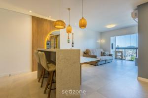 a kitchen and living room with a table and chairs at Apt w/ BBQ and Partial Ocean View ALE0803 in Piçarras