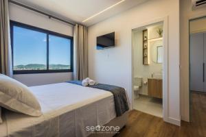 a bedroom with a bed and a large window at Apt w/ BBQ and Partial Ocean View ALE0803 in Piçarras +22 photos