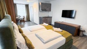 a hotel room with two beds and a flat screen tv at E&B Apartments Waiblingen bei Stuttgart in Waiblingen