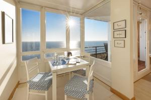 a room with a table and chairs with a view of the ocean at Strandkieker in List