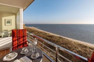 a dining table with a view of the ocean at Strandkieker in List +25 photos