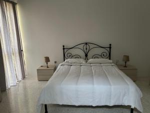 a bedroom with a large bed with white sheets and pillows at Apartment in Żebbuġ Malta in Ħal Muxi