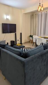 a living room with couches and a flat screen tv at Nook Cabins in Ruringʼu