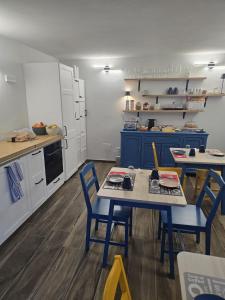 a kitchen with two tables and blue chairs in it at B&B Blue Dragonfly in Paesana