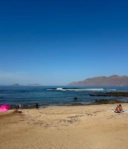 a group of people laying on the beach at apartment in La Santa, Lanzarote, village by the Sea in La Santa
