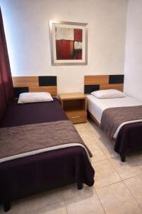 a hotel room with two beds and a picture on the wall at Depa Centrico en Monterrey in Monterrey