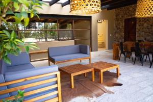a patio with two blue couches and a coffee table at Villa Ecuestre in Cedro