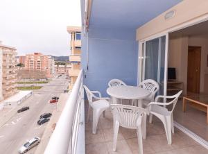 a balcony with a table and chairs and a street at APCOSTAS Pereda Mar - Familiar in Puerto de Gandía