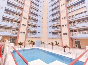 an apartment with a swimming pool in front of a building at APCOSTAS Pereda Mar - Familiar in Puerto de Gandía