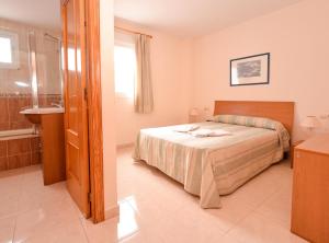 a bedroom with a bed and a bathroom with a sink at APCOSTAS Pereda Mar - Familiar in Puerto de Gandía