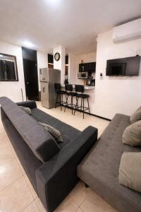 a living room with two couches and a kitchen at Depa Centrico en Monterrey in Monterrey