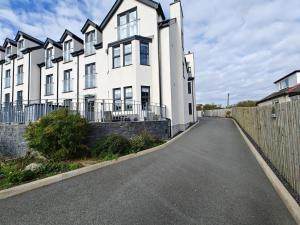 an empty street in front of a white house at 2 Bed in Benllech oc-t34071 in Benllech