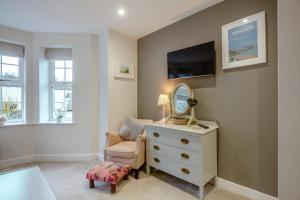 a room with a dresser and a mirror and a chair at 2 Bed in Benllech oc-t34071 in Benllech