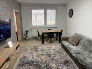 a living room with a table and a couch at Apartmán Leo in Kežmarok +3 photos