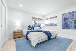 a white bedroom with a bed and a blue rug at Golf Coast Bleu III - 3158-3160 in Zephyrhills