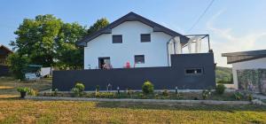 a white house with a black fence in a yard at Villa Aida in Cazin