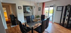 a dining room with a glass table and chairs at Villa Aida in Cazin
