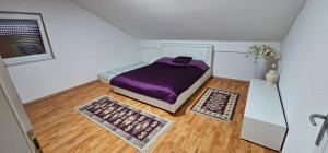a small bedroom with a bed with purple sheets at Villa Aida in Cazin