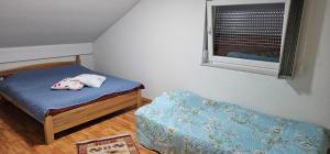 a small bedroom with a bed and a window at Villa Aida in Cazin +3 photos