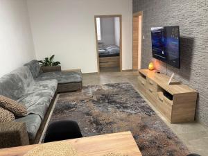 a living room with a couch and a flat screen tv at Apartmán Leo in Kežmarok