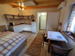 a room with a bed and a table and a kitchen at Barna kuckó in Mohács