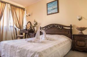 a bedroom with a bed with a white blanket on it at Hotel Saint John Baptist Nessebar in Nesebar